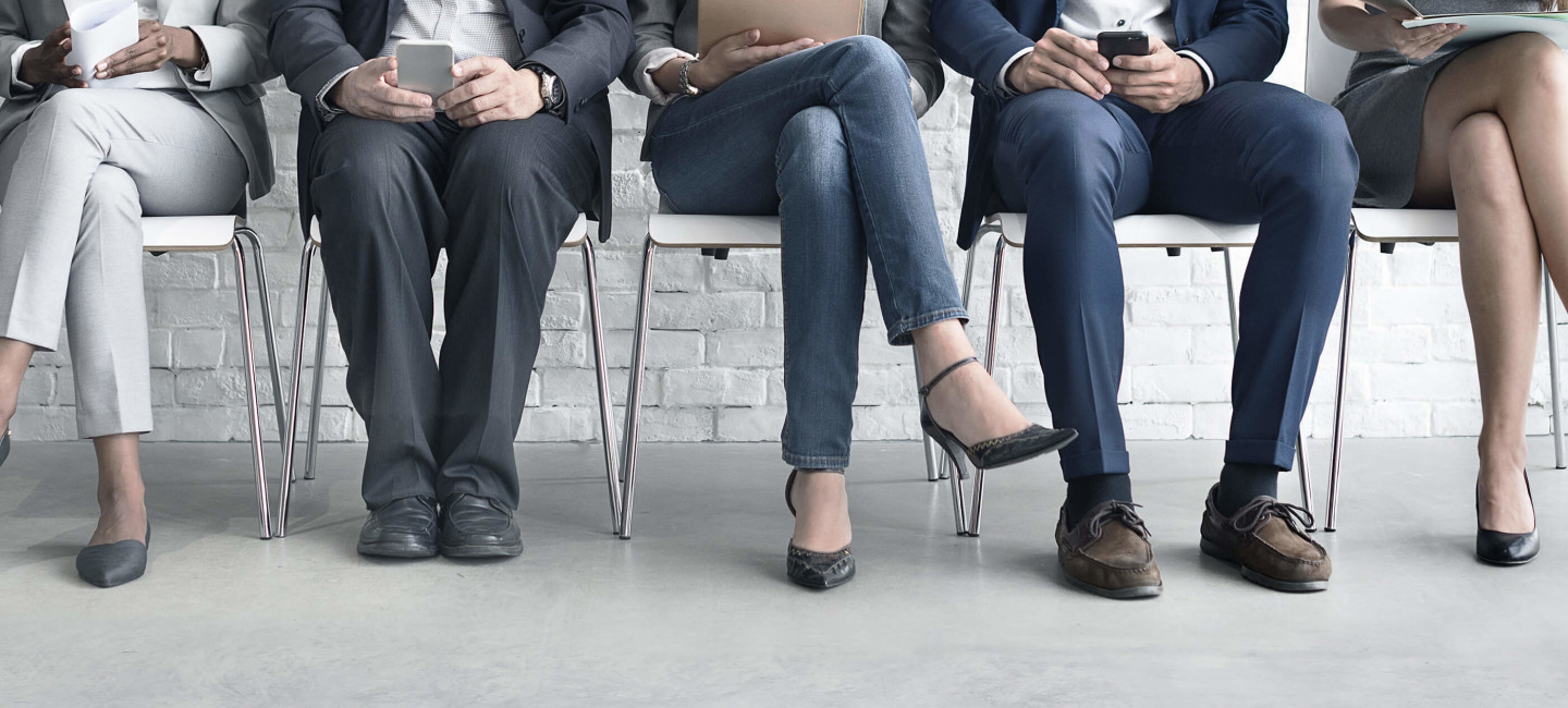 Row of job candidates sitting on seats waiting for interview