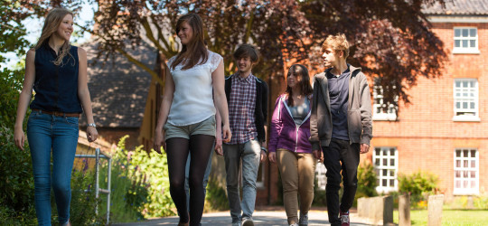 Students walking on pavement through Paston Lawns campus
