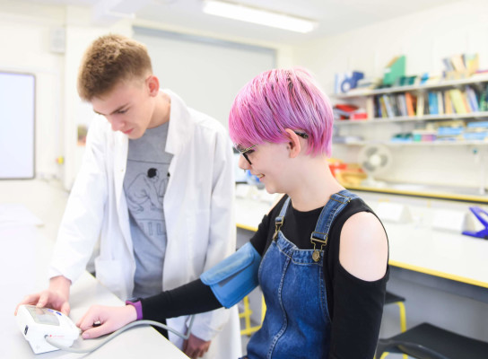 Medical science students testing blood pressure in Paston science lab